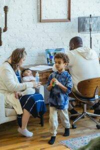 mother sitting on chair holding a bottle of milk for baby