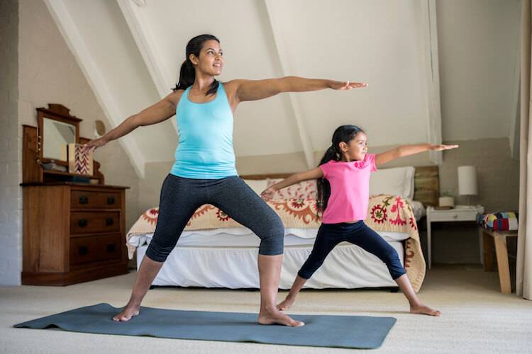 mother and daughter doing yoga exercise