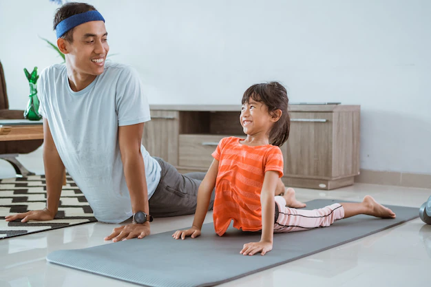 father and daughter doing yoga exercise